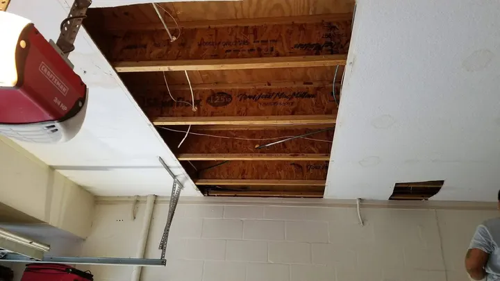 Garage ceiling with drywall removed and joists exposed