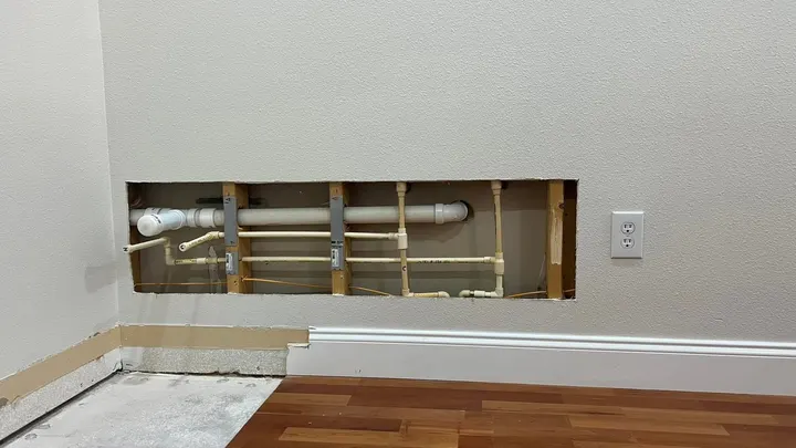Wall cut open to replace water supply and drain lines