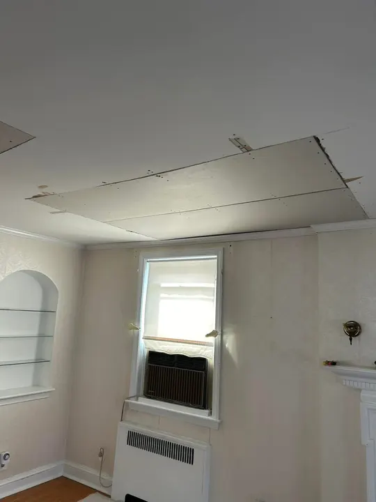 Living room ceiling with sagging, broken drywall panels