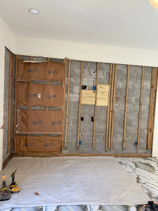 Concrete-block wall with wood furring, insulation and boxes before new drywall