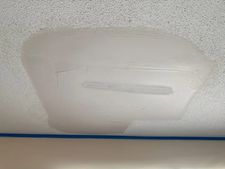 Ceiling drywall patch taped and feathered with joint compound