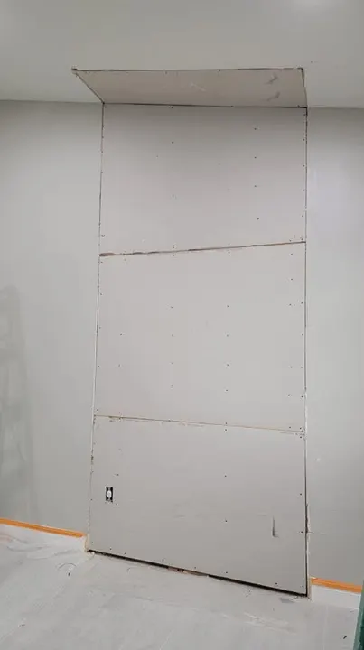 New drywall panels installed in a full-height wall section