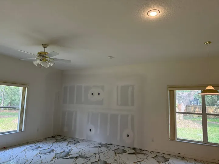 Handyman & Remodeling — Living room wall with new drywall patches taped and mudded