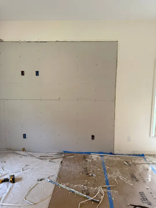 Freshly hung drywall sheets on a living room wall